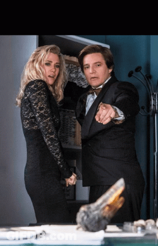 A Man In A Tuxedo Pointing At A Woman In A Black Lace Dress GIF