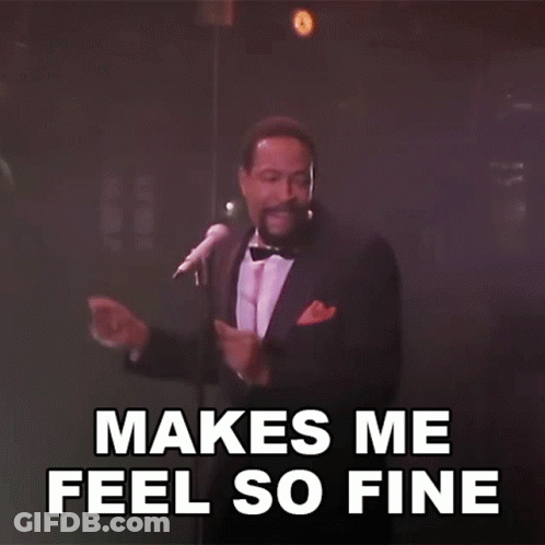 A Man In A Tuxedo Singing Into A Microphone With The Words " Makes Me Feel So Fine " Behind Him GIF