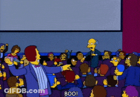 A Man In A Tuxedo Stands In Front Of A Crowd And Says Boo On The Screen GIF