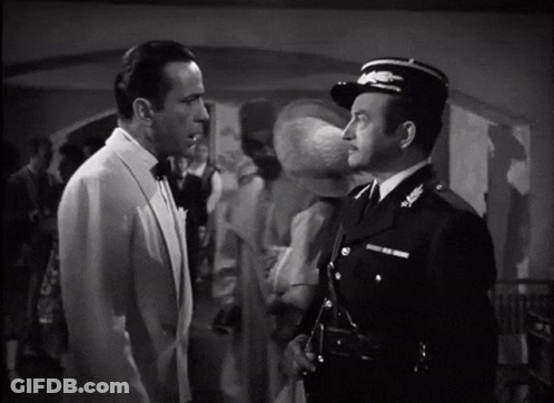 A Man In A Tuxedo Stands Next To A Man In A Uniform GIF