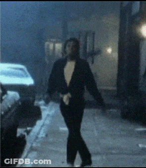 A Man In A Tuxedo Walking Down A Street GIF