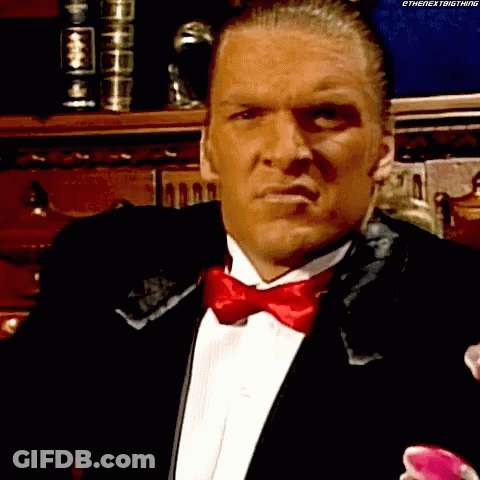 A Man In A Tuxedo With A Red Bow Tie Is Looking At Something GIF