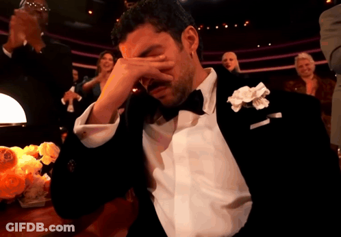 A Man In A Tuxedo With A White Flower In His Lapel Is Crying GIF
