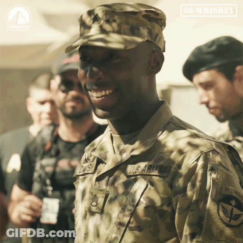 Man In Army Uniform Smiling In Front Of 68 Whiskey Sign GIF