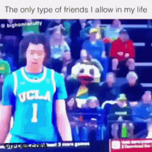 A Man In A Ucla Jersey Is Standing In Front Of A Crowd . GIF