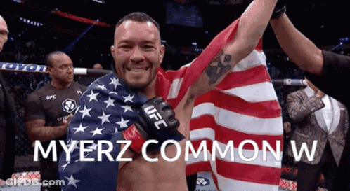 A Man In A Ufc Glove Holds Up An American Flag GIF