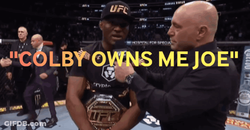 A Man In A Ufc Hat Is Being Pinned By Another Man GIF