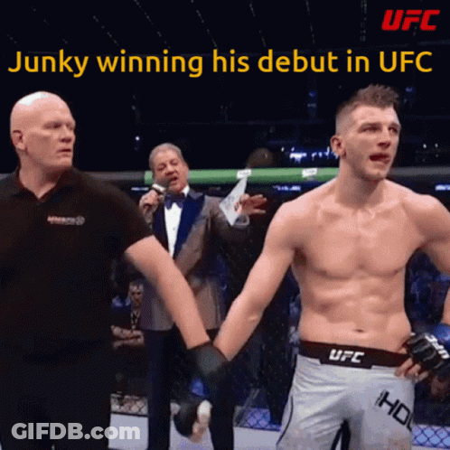A Man In A UFC Shorts Holds The Hand Of Another Man GIF