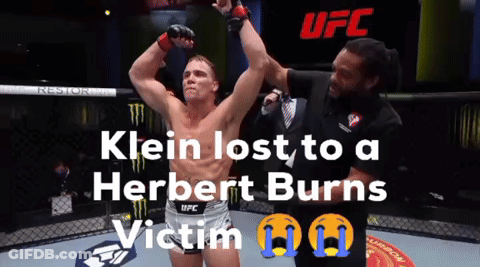 A Man In A UFC Shorts Stands In A Cage GIF
