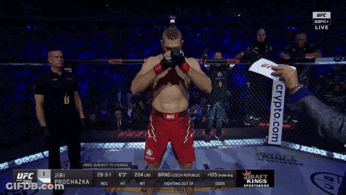 A Man In A Ufc Shorts Stands In Front Of A Cage GIF
