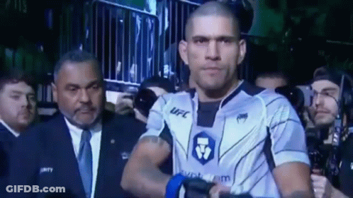 A Man In A Ufc Uniform Is Walking Through A Crowd . GIF