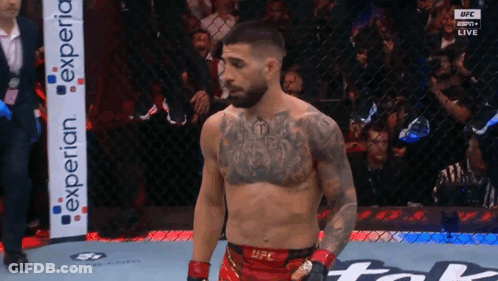 A Man In A Ufc Uniform Stands In A Cage GIF