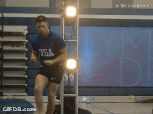 A Man In A Usa Shirt Jumps In The Air GIF