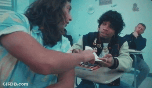 A Man In A Varsity Jacket Is Talking To Another Man In A Blue Shirt GIF