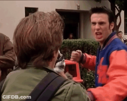A Man In A Varsity Jacket Is Yelling At Another Man . GIF