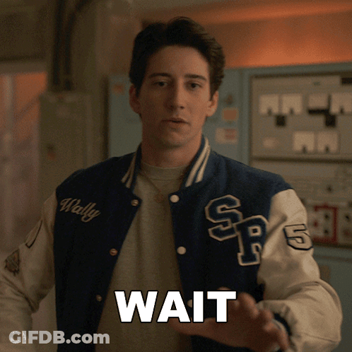 A Man In A Varsity Jacket With The Word Wait On It GIF