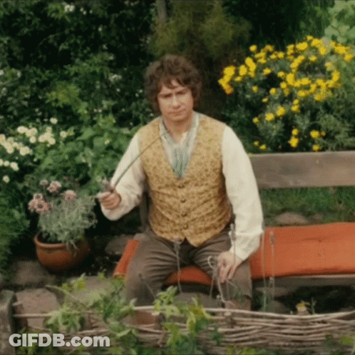A Man In A Vest Is Sitting On A Bench Holding A Sword GIF