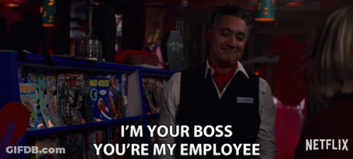 A Man In A Vest Says " I 'M Your Boss You 'Re My Employee " In Front Of A Shelf Of Magazines GIF