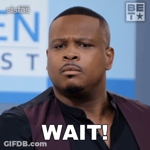 A Man In A Vest Says Wait In Front Of A Sign That Says Sistas GIF