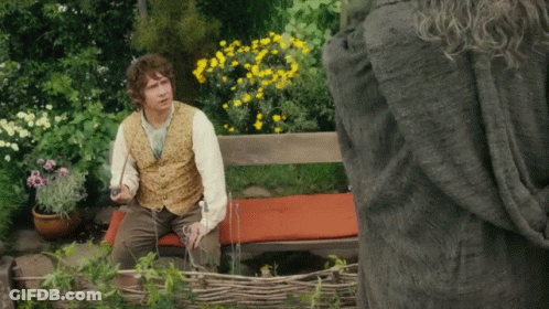 Man In Vest Sitting With Flowers GIF