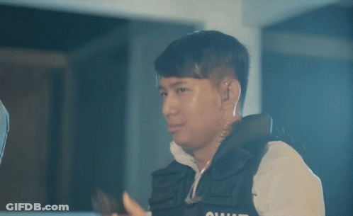 A Man In A Vest With The Word Squad On It Holds A Gun GIF