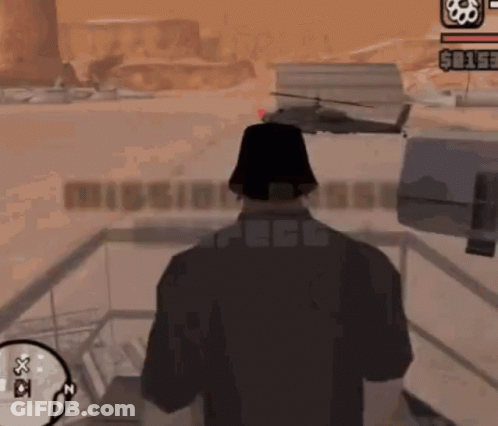 A Man In A Video Game Is Standing In Front Of A Mission Base Sign GIF