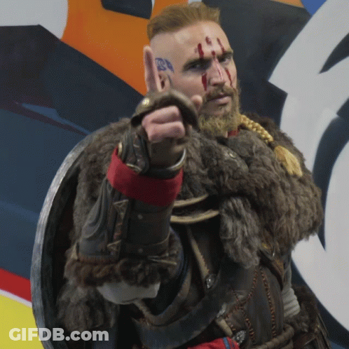 A Man In A Viking Costume Has Blood On His Face And Is Pointing GIF