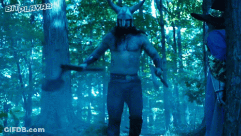 A Man In A Viking Costume Is Holding A Axe In A Forest With The Words Bi-Playas Written Above Him GIF