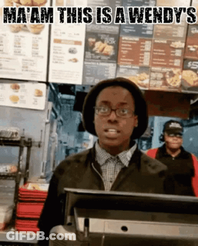 A Man In A Wendy 'S Restaurant Behind A Counter GIF
