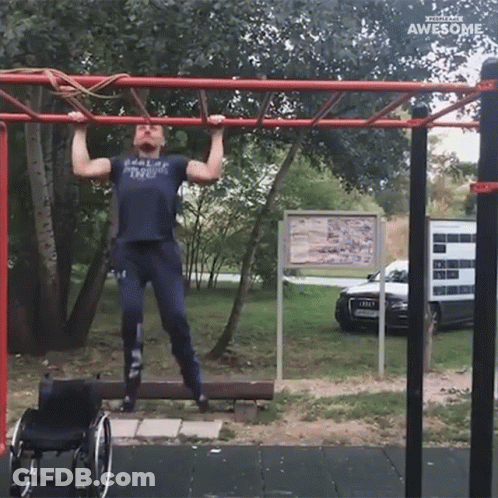 A Man In A Wheelchair Is Doing Pull Ups On A Bar GIF
