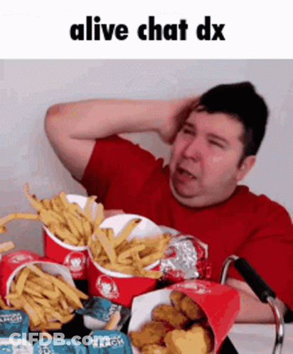 A Man In A Wheelchair Is Eating French Fries And Chicken Nuggets . GIF