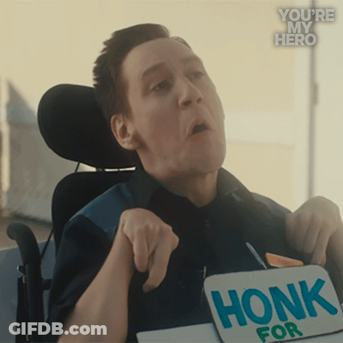 A Man In A Wheelchair Is Holding A Sign That Reads Honk For GIF