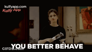 A Man In A Wheelchair Is Sitting On A Couch In A Living Room And Says `` You Better Behave '' . GIF