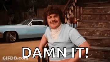 A Man In A Wheelchair Is Sitting On A Set Of Stairs Next To A Car And Says `` Damn It '' . GIF