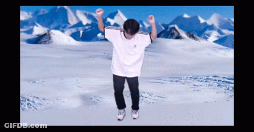 A Man In A White Adidas Shirt Is Dancing In Front Of Snowy Mountains GIF