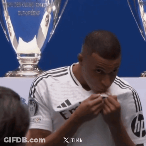 A Man In A White Adidas Shirt Is Eating Something GIF