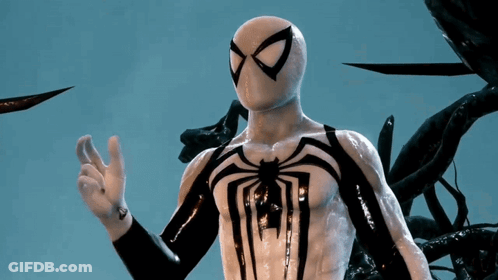 A Man In A White And Black Spiderman Costume Is Giving The Ok Sign GIF
