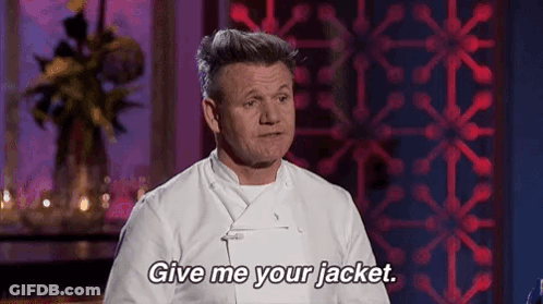 A Man In A White Chef 'S Jacket Is Standing In Front Of A Red Wall And Says `` Give Me Your Jacket '' . GIF