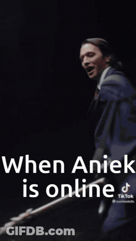 A Man In A White Coat And Tie Is Standing In Front Of A Wall With The Words `` When Anick Is Online '' . GIF