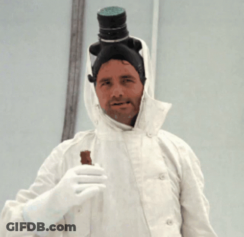 A Man In A White Coat Has A Bottle On His Head And Is Holding A Piece Of Chocolate GIF