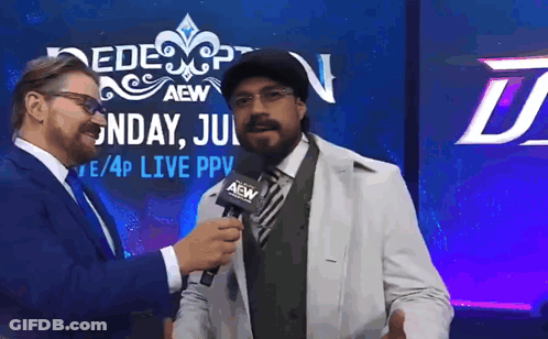 A Man In A White Coat Is Being Interviewed By A Man In A Suit GIF