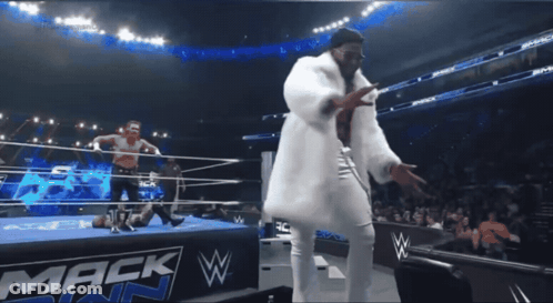 A Man In A White Fur Coat Is Dancing In Front Of A Mack W Sign GIF