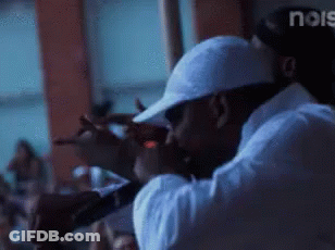 A Man In A White Hat Is Singing Into A Microphone In Front Of A Crowd And The Word Noise Is Visible In The Corner GIF