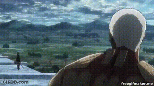 A Man In A White Hat Is Standing In Front Of A Mountain Range . GIF