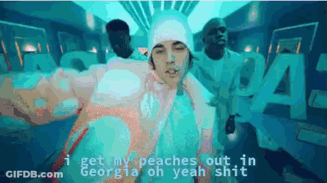 A Man In A White Hat Is Standing In Front Of A Sign That Says Georgia GIF
