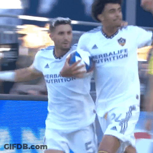 A Man In A White Herbalife Nutrition Jersey Holds A Ball GIF