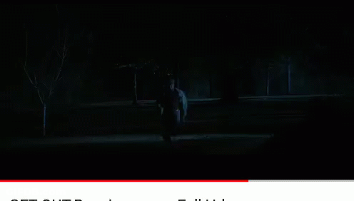 A Man In A White Hoodie Stands Next To Another Man In A Black Jacket GIF