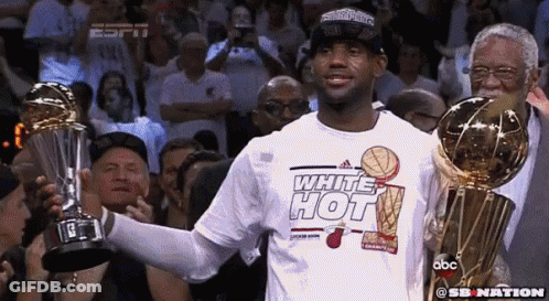 A Man In A White Hot Shirt Holds A Trophy GIF