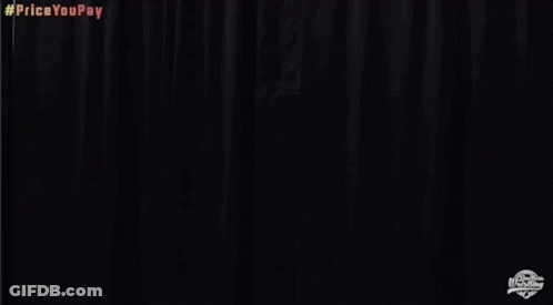 A Man In A White Jacket And Gold Shorts Is Standing In Front Of A Black Curtain And Screaming . GIF