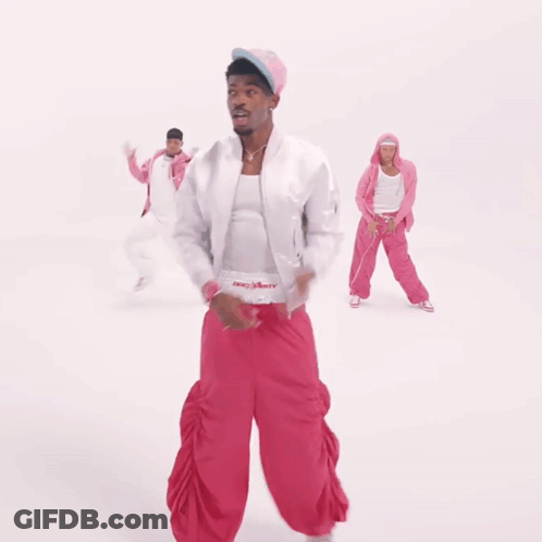 A Man In A White Jacket And Pink Pants Is Dancing With Two Other People GIF